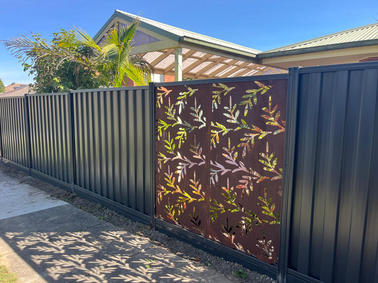 1.95m high Monument Colorbond front boundary fence with aluminium sleepers, decorative screening panels and side gate completed for an existing home in Beaconsfield.