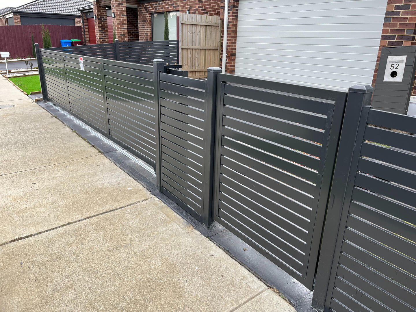 Monument aluminium slat pedestrian gate with horizontal slats and 10mm spacing. Custom Monument aluminium slat side access gate completed in Cranbourne featuring horizontal slats, 10mm gaps and a low-maintenance powder-coated finish for secure modern entry.