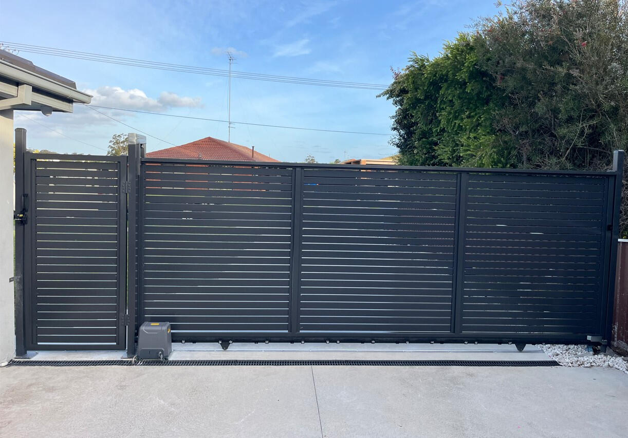 Monument aluminium slat sliding gate with matching pedestrian gate installed in Moe. Custom 4m Monument aluminium slat motorised sliding gate with matching pedestrian access gate completed in Moe for improved driveway security, modern street appeal and low-maintenance access control.