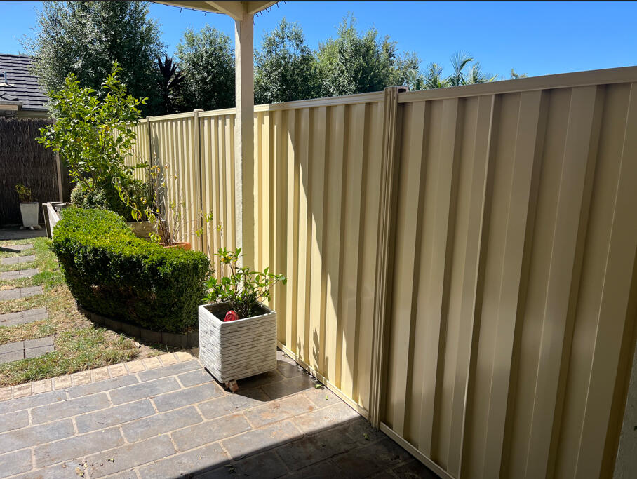 Domain Colorbond boundary fence with timber sleepers replacing an old timber fence. 2m high Domain Colorbond privacy fence with timber sleepers completed for a shared boundary fence replacement between existing homes in Narre Warren South.