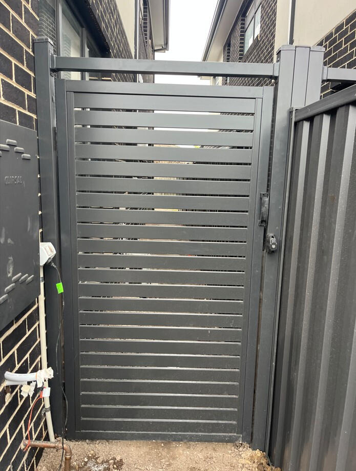 Custom aluminium slat pedestrian gate completed in Dandenong with reinforced steel posts for added strength, installed in one day to complement the architectural design of the new home.