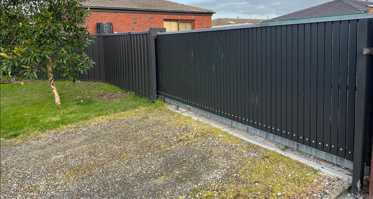 Custom 6m aluminium slat sliding gate completed in Cranbourne North featuring vertical slats, 10mm gaps and a remote-controlled automatic motor system for secure modern driveway access.