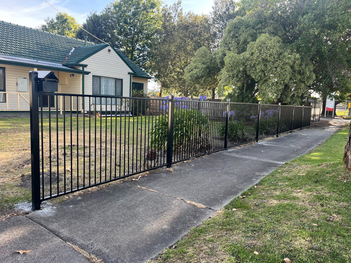 1.2m high flat top metal front fencing completed in Narre Warren to improve residential security, define the property boundary and modernise the appearance of an older home.