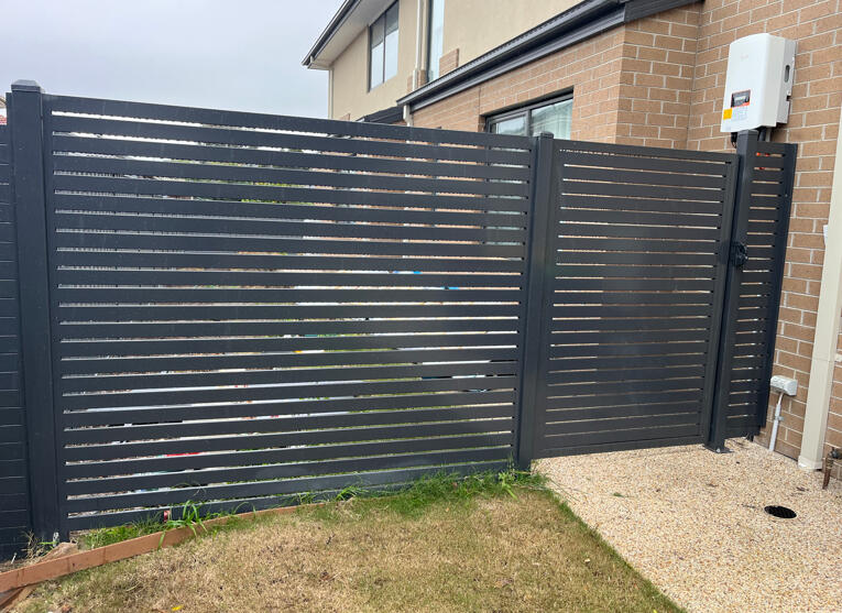 Modern black aluminium slat side gate and privacy screen fencing completed in Noble Park North to upgrade existing Colorbond fencing with a more architectural look.