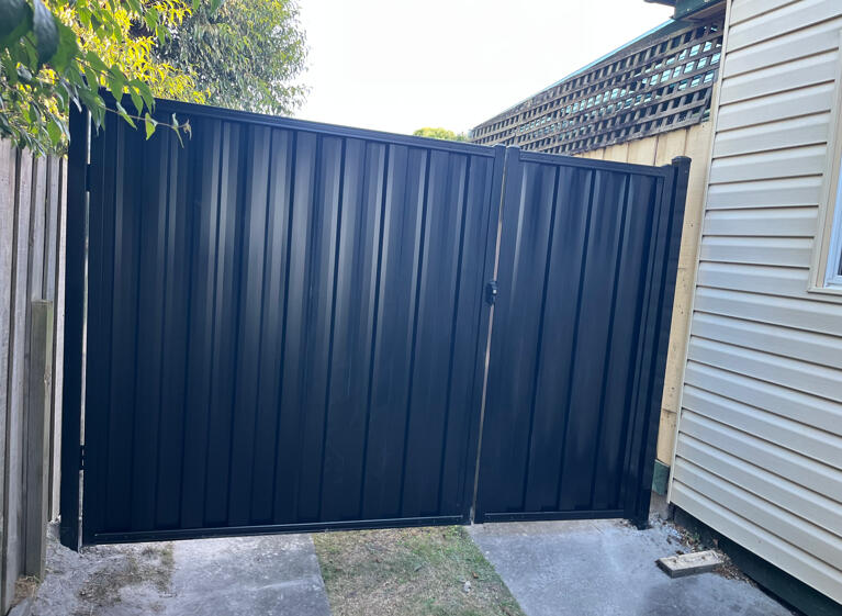 Custom black driveway gates completed in Moe featuring a 3m wide opening with integrated pedestrian gate design for practical vehicle access and improved property security.
