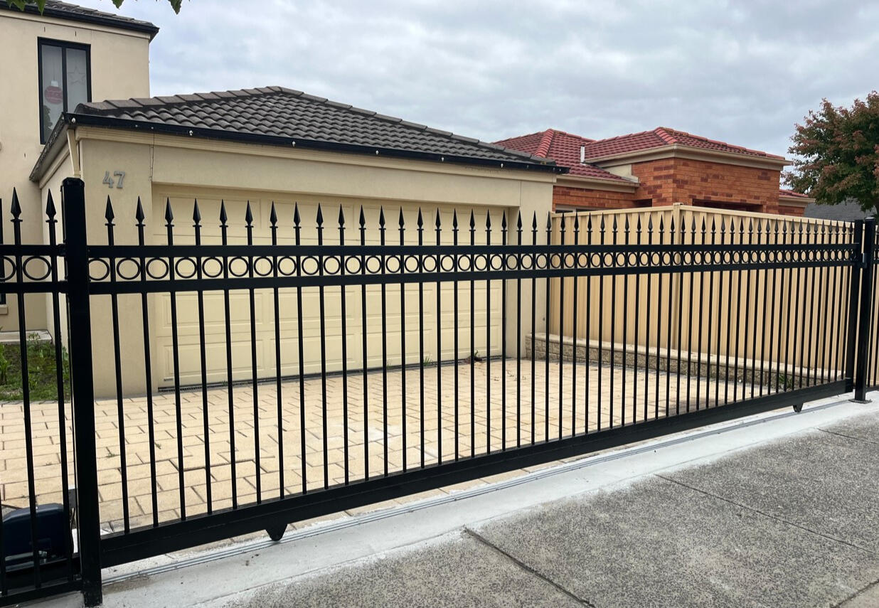 Custom ring and spear sliding gate with matching front fence and automatic motor system Custom 6m ring and spear motorised sliding gate with matching front boundary fencing completed in Berwick for a premium driveway entrance and improved property security.