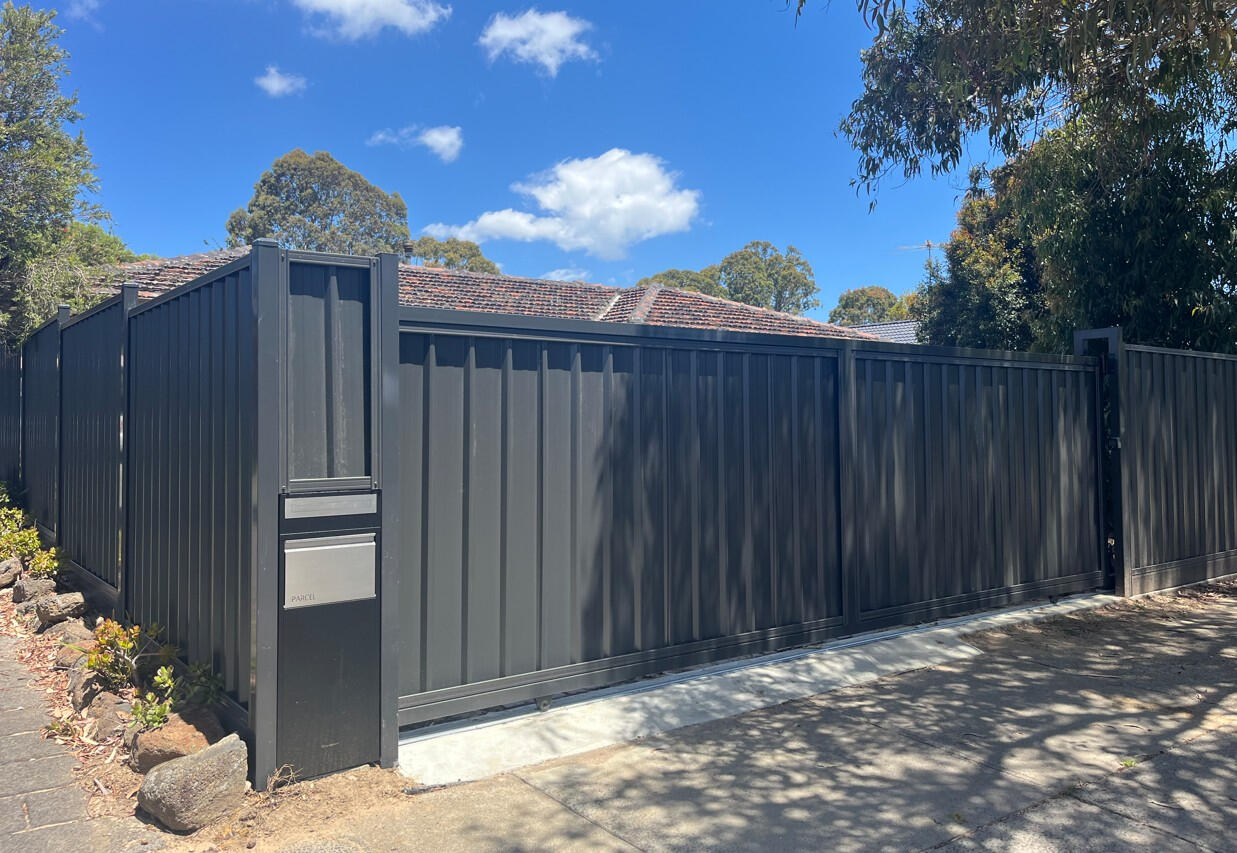 6m automated Colorbond driveway gate completed in Carrum Downs featuring remote controls, keypad entry, parcel box, safety sensors and motorised access system for enhanced residential security.