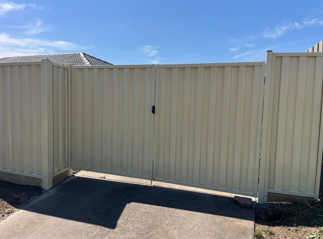Custom cream Colorbond double swing driveway gates completed in Cranbourne North as a replacement for old timber gates, improving both security and the overall appearance of the home.