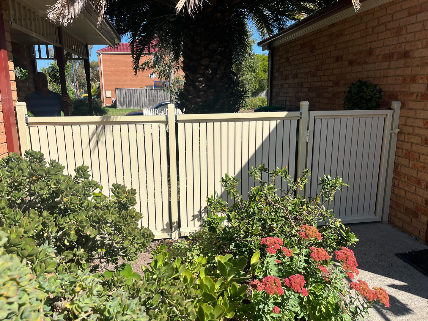 Cream aluminium slat garden fence and gate with vertical slats and 10mm spacing. Custom aluminium slat garden fence and pedestrian gate completed in Lynbrook featuring vertical slats, 10mm gaps and a modern cream powder-coated finish for secure outdoor access.