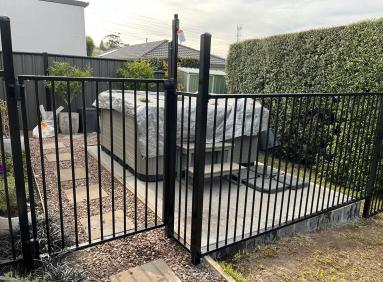 Pool fencing with child-safe gate and extra-high posts installed around a spa in Pakenham. Custom pool and spa fencing completed in Pakenham featuring extra-high posts, child-lock gate system and secure safety enclosure for a residential outdoor area.